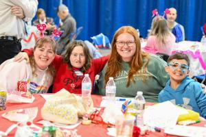 Students sitting with attendees at the Valentines dance