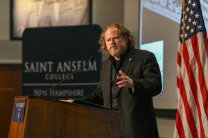 Dr. Morgan Marietta speaking behind a podium at the NHIOP