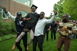 A family celebrates by the Jean Student Center following Commencment