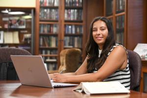 Josephine Rizzo ’25 sitting at her computer in the NHIOP library