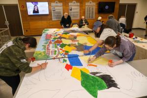 Many people working on the mural