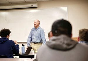 Senator Sununu stands in front of classroom and smiles