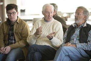 Three men sitting and engaging in conversation