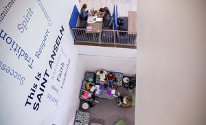 Shot of word cloud wall in Jean Student Center with students studying