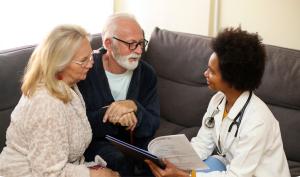 Nurse speaks with elderly couple