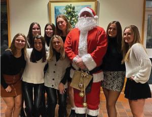 A group of students pose for a photo with Santa