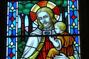 Stain glass Jesus holding a child
