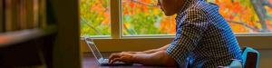 student works on a laptop in the library