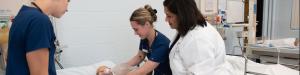 Student nurses practicing a simulation lab under the watch of their instructor