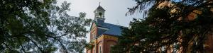 Front facade of a large campus building (Alumni Hall) with a cupola
