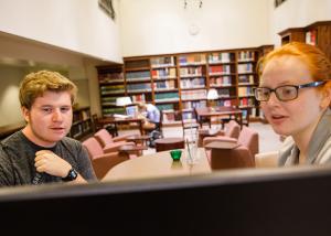 students talking in front of a computer