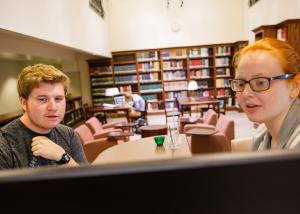 librarian helping a student at the reference desk