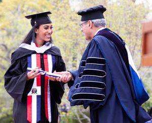 student receives diploma from President Favazza