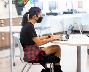 student works on a laptop in the library