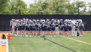 The men’s lacrosse team gathered together on the field
