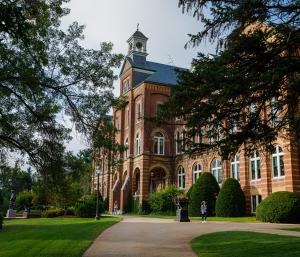 Front facade of a large campus building (Alumni Hall) with a cupola