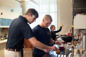 Instructor assists a student in the lab