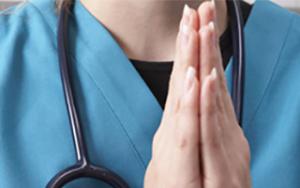Hands of a nurse folded in prayer