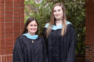 Two graduate students at their hooding ceremony