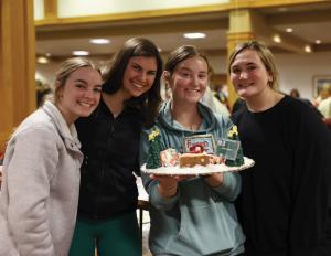Student gingerbread team holding their creation