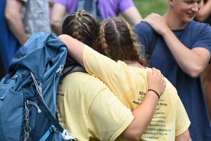 Two members of the Road for Hope walk embrace after arriving back on campus