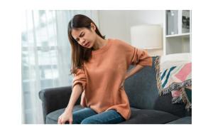 Women holding her back in pain