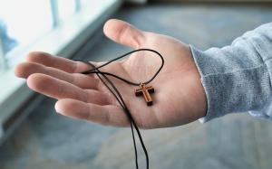 Hand holding a cross necklace