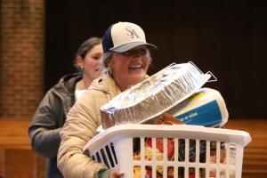 Student carrying a Thanksgiving basket
