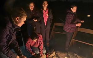 Students gathered by a fire during a retreat
