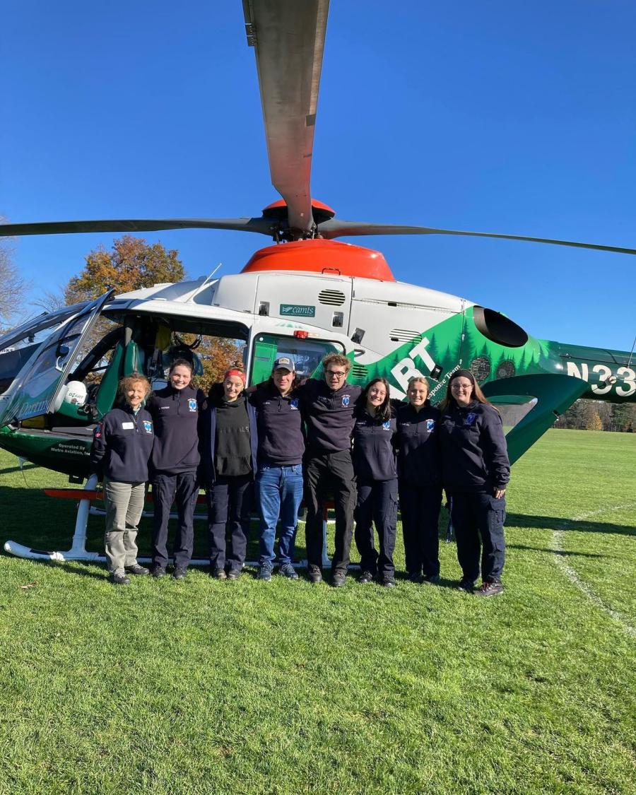 EMS team posing in front of a medical helicopter